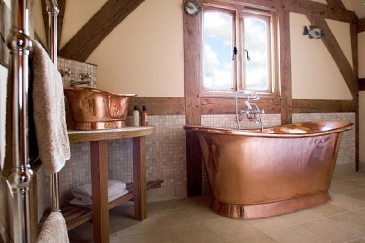 polished copper tub on a attic bathroom
